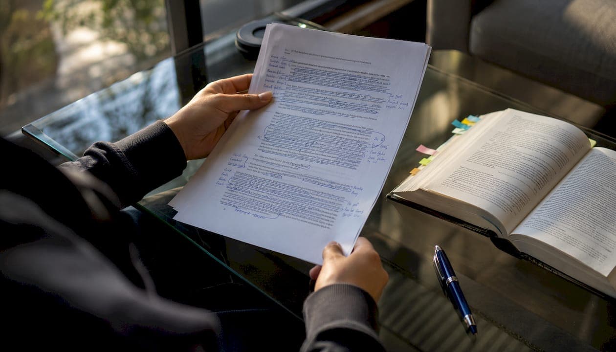 Hands marking in-text citations on paper