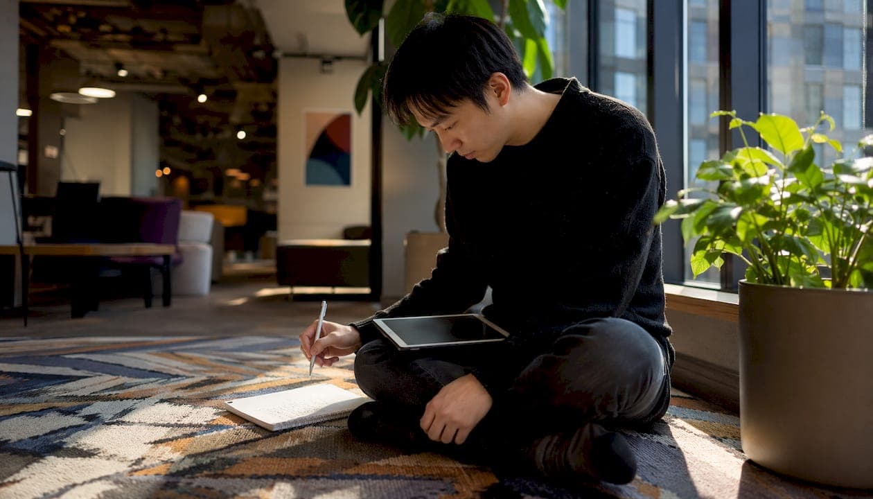 Researcher using tablet with notes in library