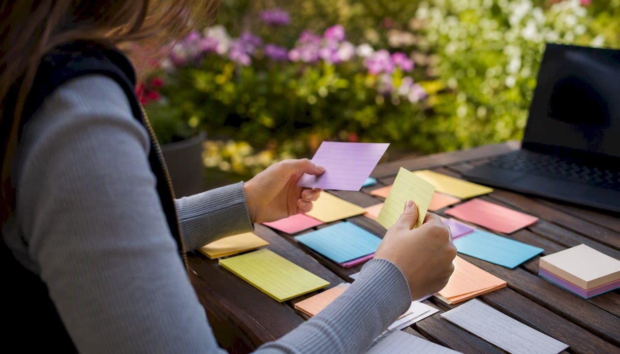 Hands arranging research note cards